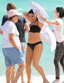 Kelly Brook rides a bicycle barefoot between photo shoot locations in Miami