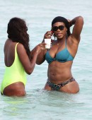 Serena Williams shows off her fit body as she takes a dip in the ocean with a friend on Miami Beach