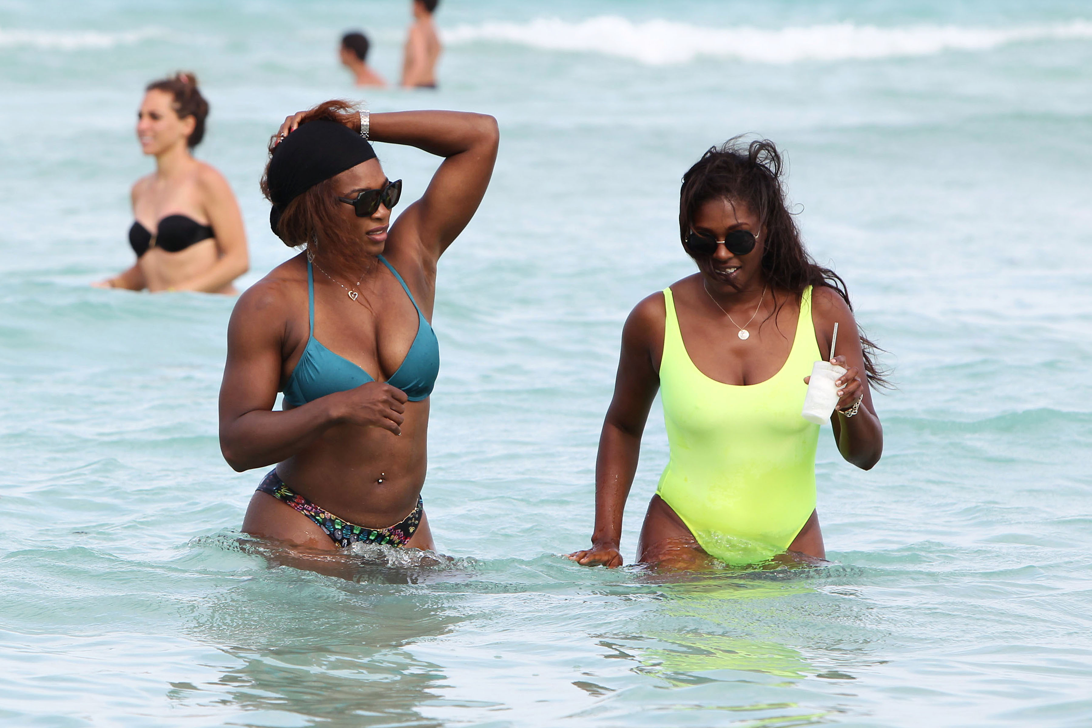 Serena Williams shows off her fit body as she takes a dip in the ocean with a friend on Miami Beach