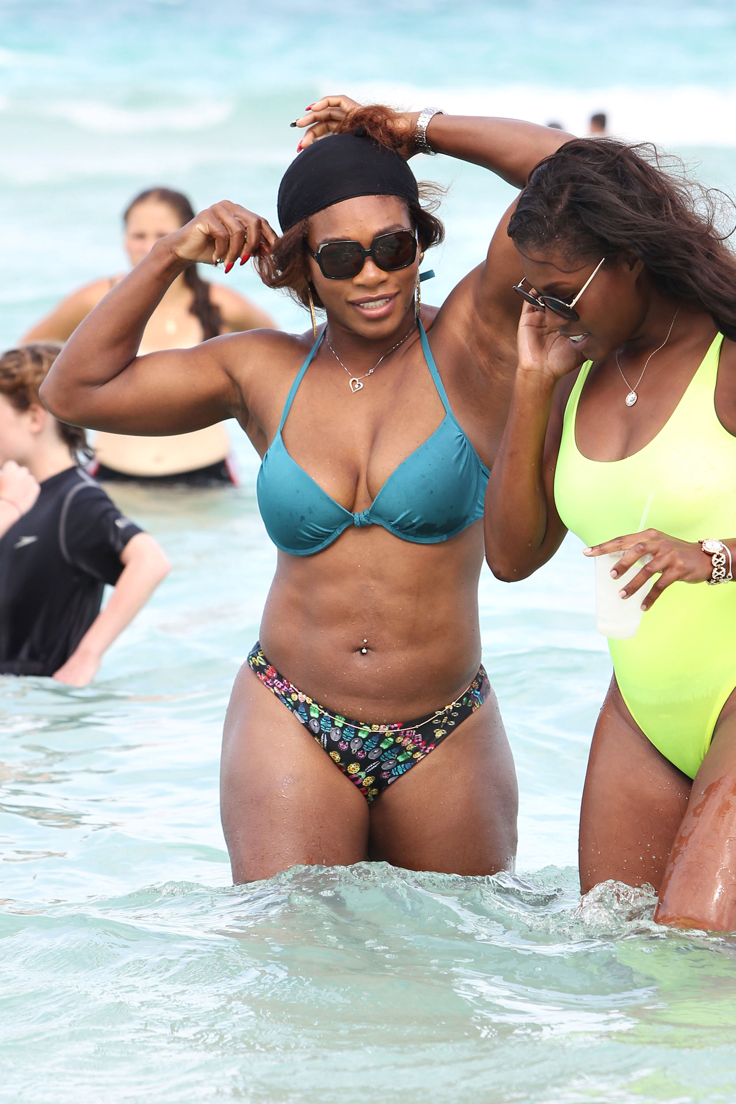 Serena Williams shows off her fit body as she takes a dip in the ocean with a friend on Miami Beach