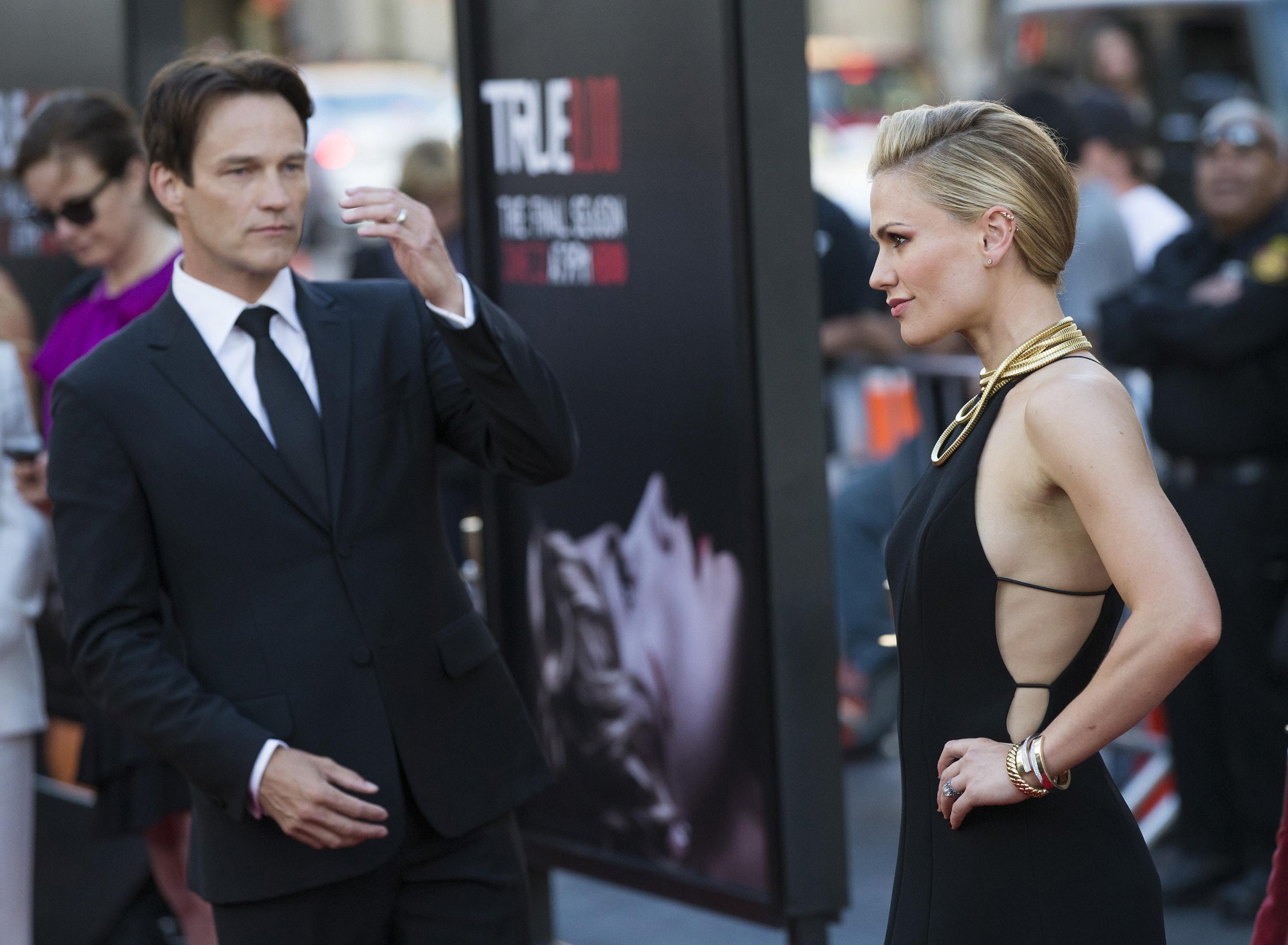 Cast member Paquin poses, as her husband and co-star Moyer watches, at the premiere of the seventh and final season of the HBO television series "True Blood" in Hollywood