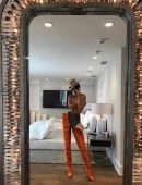 In the picture, Kendall pairs jeans with waist-high orange boots, a hat, and literally nothing else. Kendall captioned the picture, "Playing dress up."