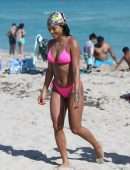 Karrueche Tran shows off her bikini body in a pink bikini as she hits the beach with boyfriend Victor Cruz in Miami